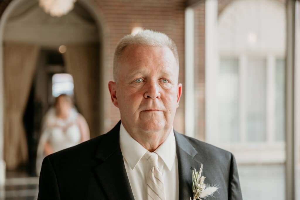 Father of the bride waits for emotional first look with bride at Kansas City Missouri wedding venue
