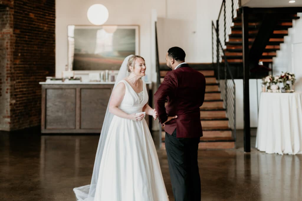 Bride cries happy tears with groom during first look at industrial Crossroads District wedding venue in Kansas City Missouri