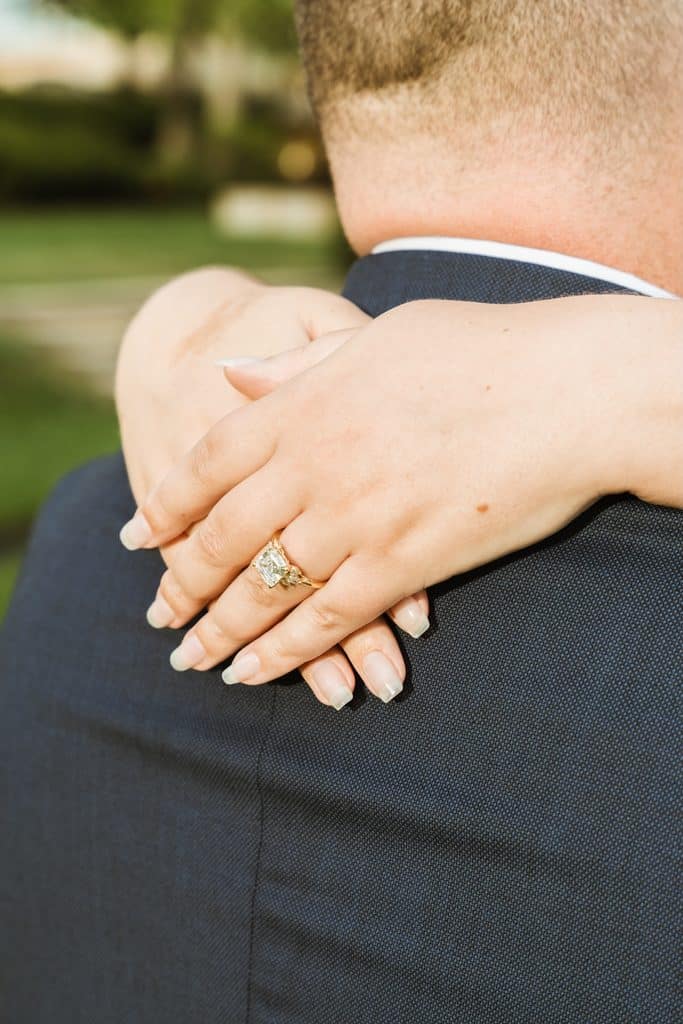 Close-up of an engagement ring on her hand resting on his shoulder at the Nelson-Atkins in Kansas City