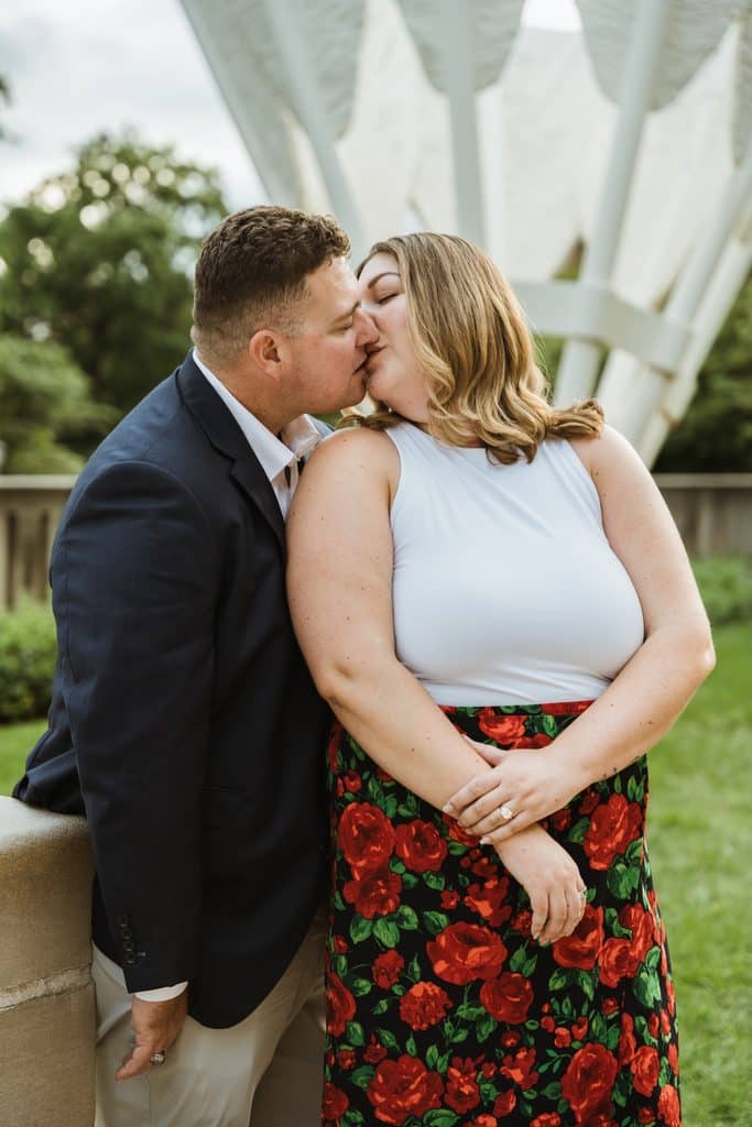 Engaged couple kisses in front of one of the Shuttlecocks sculptures at the Nelson-Atkins in Kansas City
