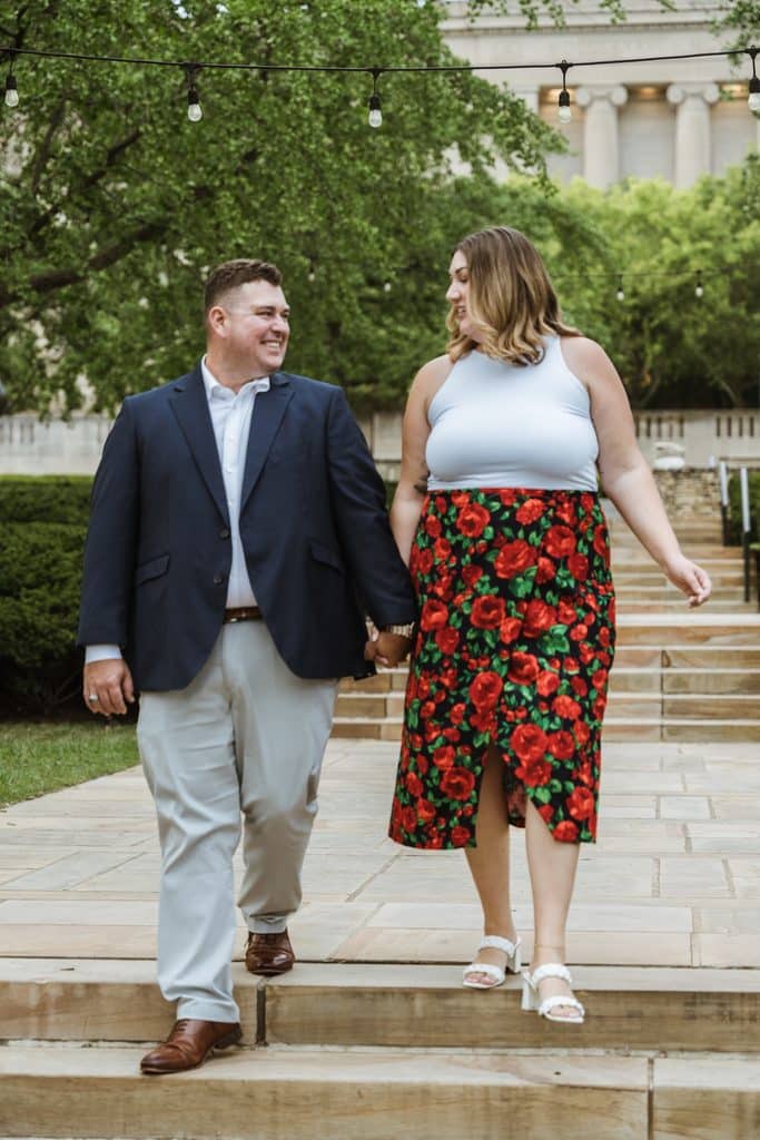 Engaged couple laughs as they walk down the museum steps at the Nelson-Atkins in Kansas City