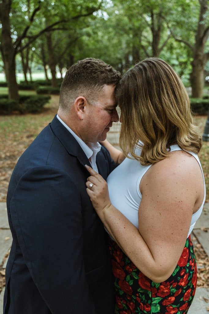 Bride-to-be rests her forehead against her fiance's with her hand on his jacket at the Nelson-Atkins in Kansas City